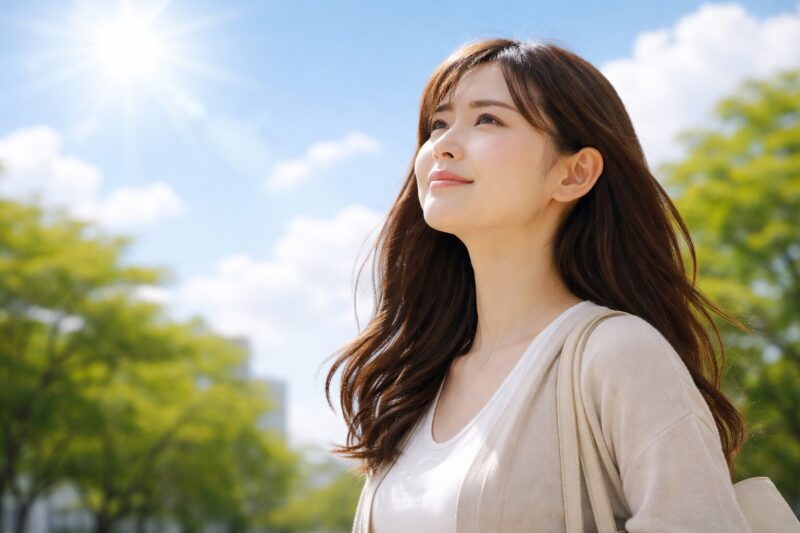 晴れた空を見上げる日本人女性 気圧上昇のイメージ